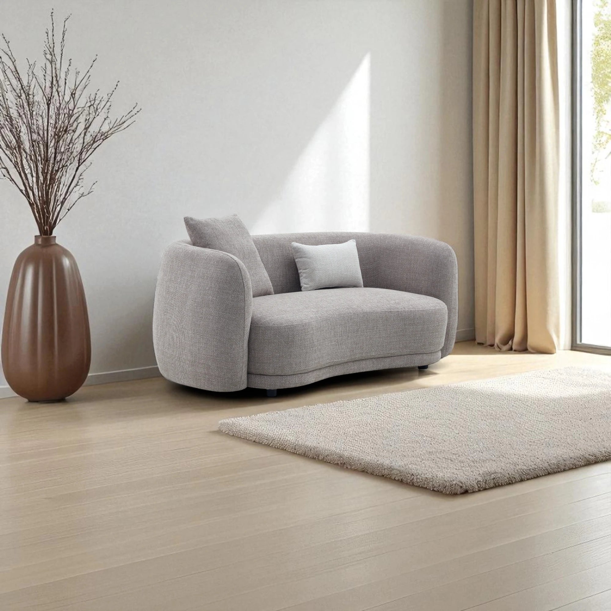 Divano 2 posti in tessuto tortora con forma curva e asimmetrica, seduta ergonomica, imbottitura avvolgente e design moderno ed elegante per soggiorno raffinato.