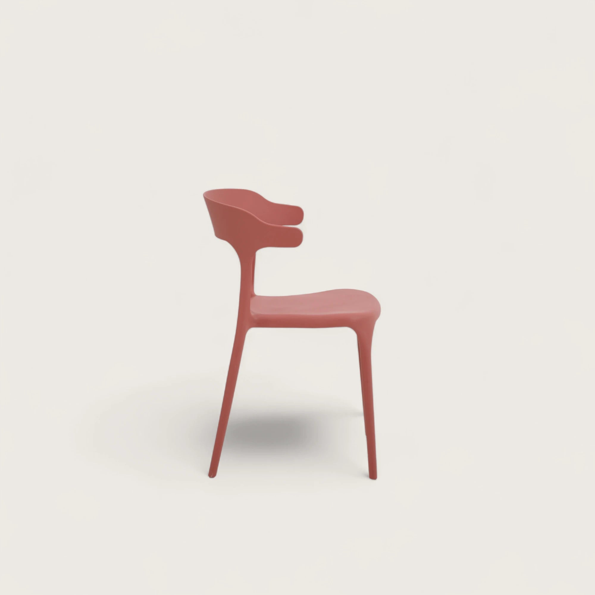 Sedia Katie in polipropilene terracotta, impilabile, con seduta curva e schienale sagomato con sporgenze laterali, design moderno per interni ed esterni.