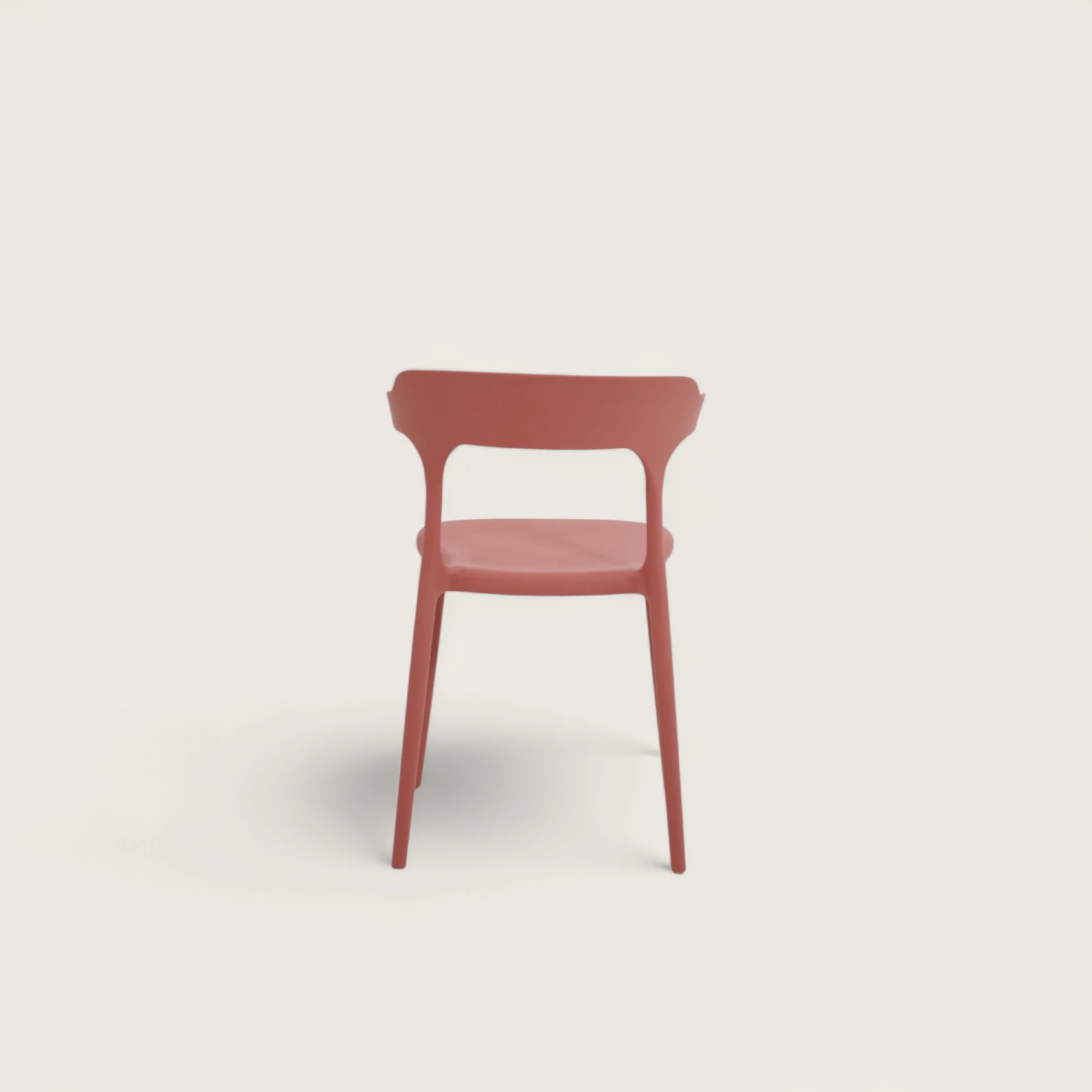 Sedia Katie in polipropilene terracotta, impilabile, con seduta curva e schienale sagomato con sporgenze laterali, design moderno per interni ed esterni.
