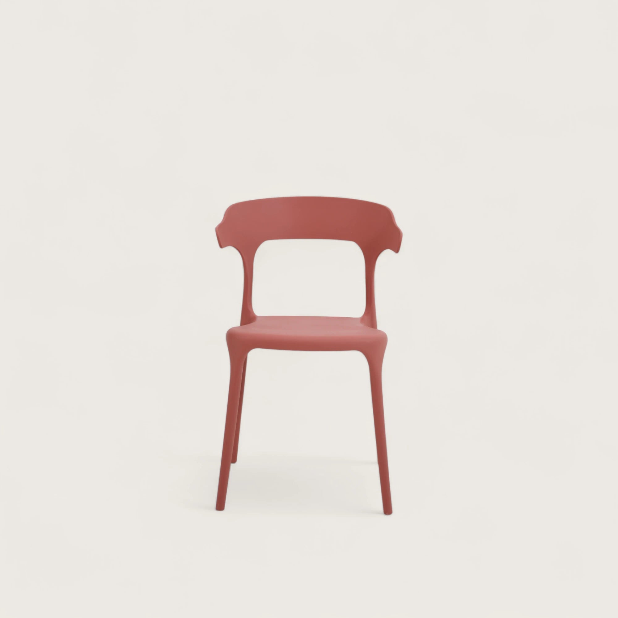 Sedia Katie in polipropilene terracotta, impilabile, con seduta curva e schienale sagomato con sporgenze laterali, design moderno per casa e giardino.