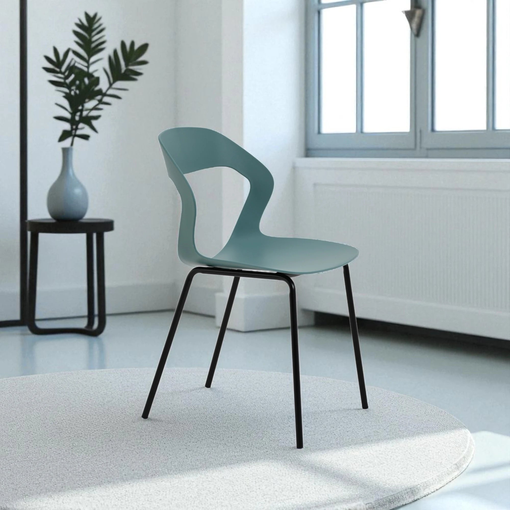 La sedia con seduta e schienale in polipropilene e gambe in metallo nero. Colore petrolio, design elegante e materiali resistenti, perfetta per arredare interni con stile e comfort.