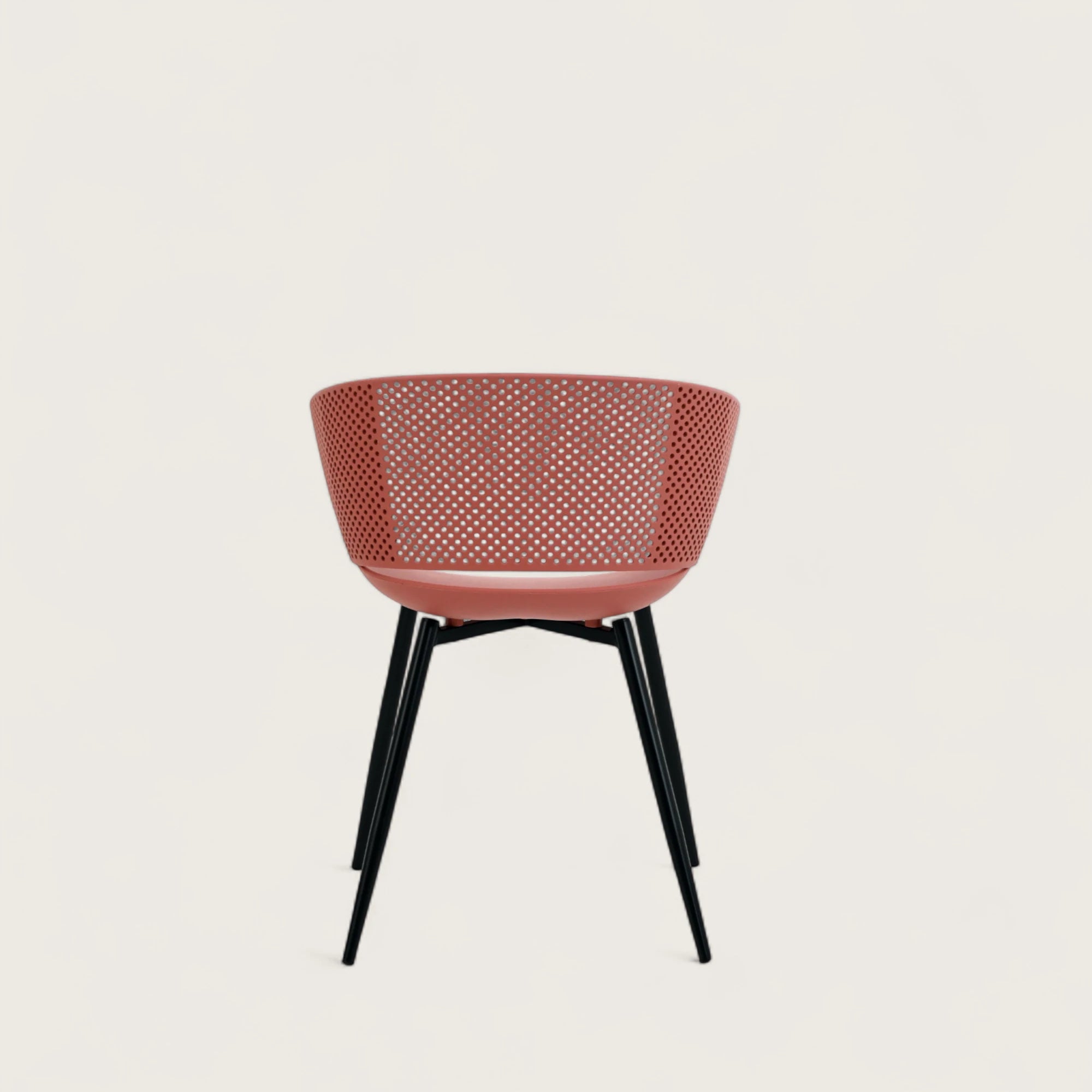 Sedia con scocca in polipropilene colore terracotta, schienale avvolgente e gambe in metallo nero opaco, ideale per sale da pranzo, cucine e spazi contract.