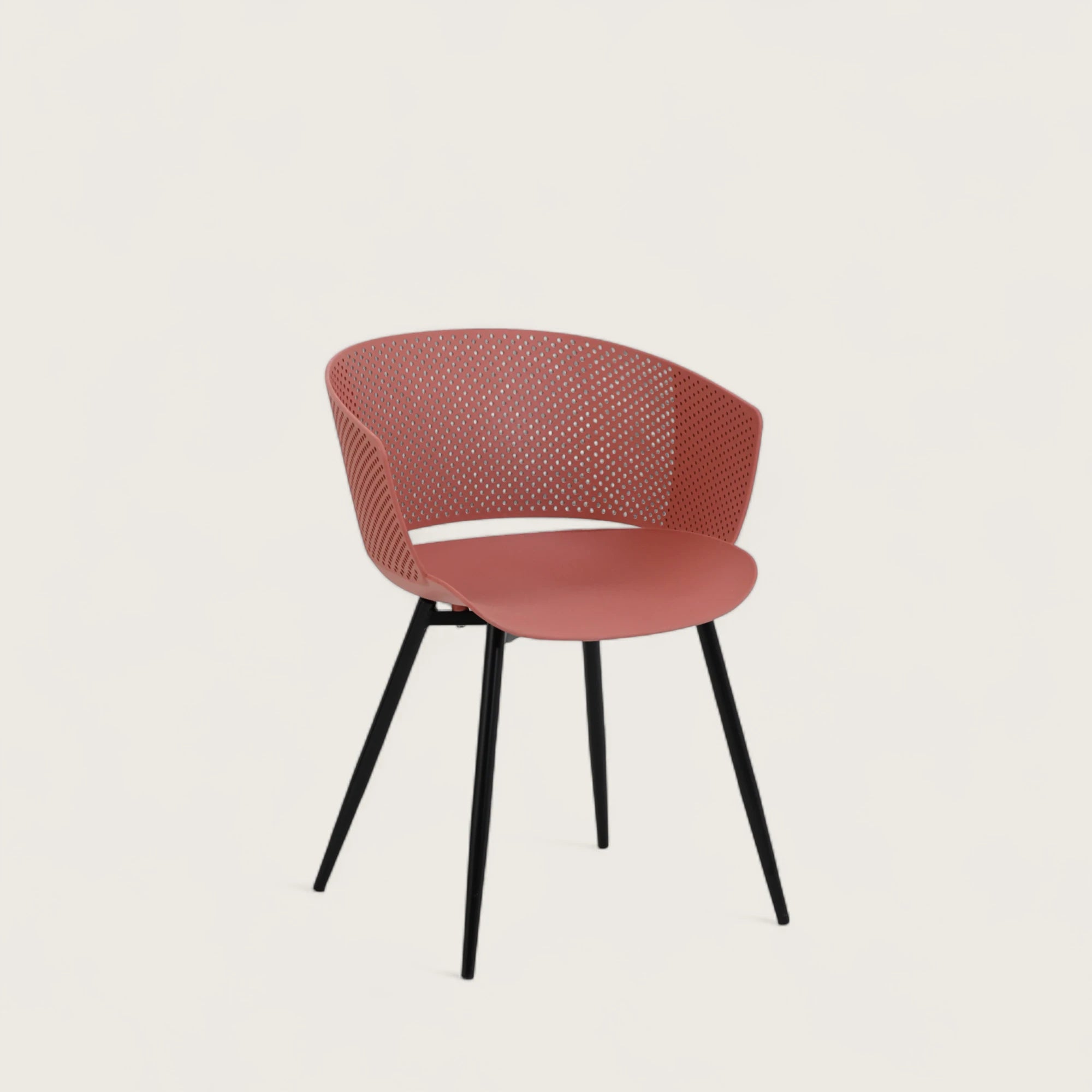 Sedia con scocca in polipropilene colore terracotta, schienale avvolgente e gambe in metallo nero opaco, ideale per sale da pranzo, cucine e spazi contract.