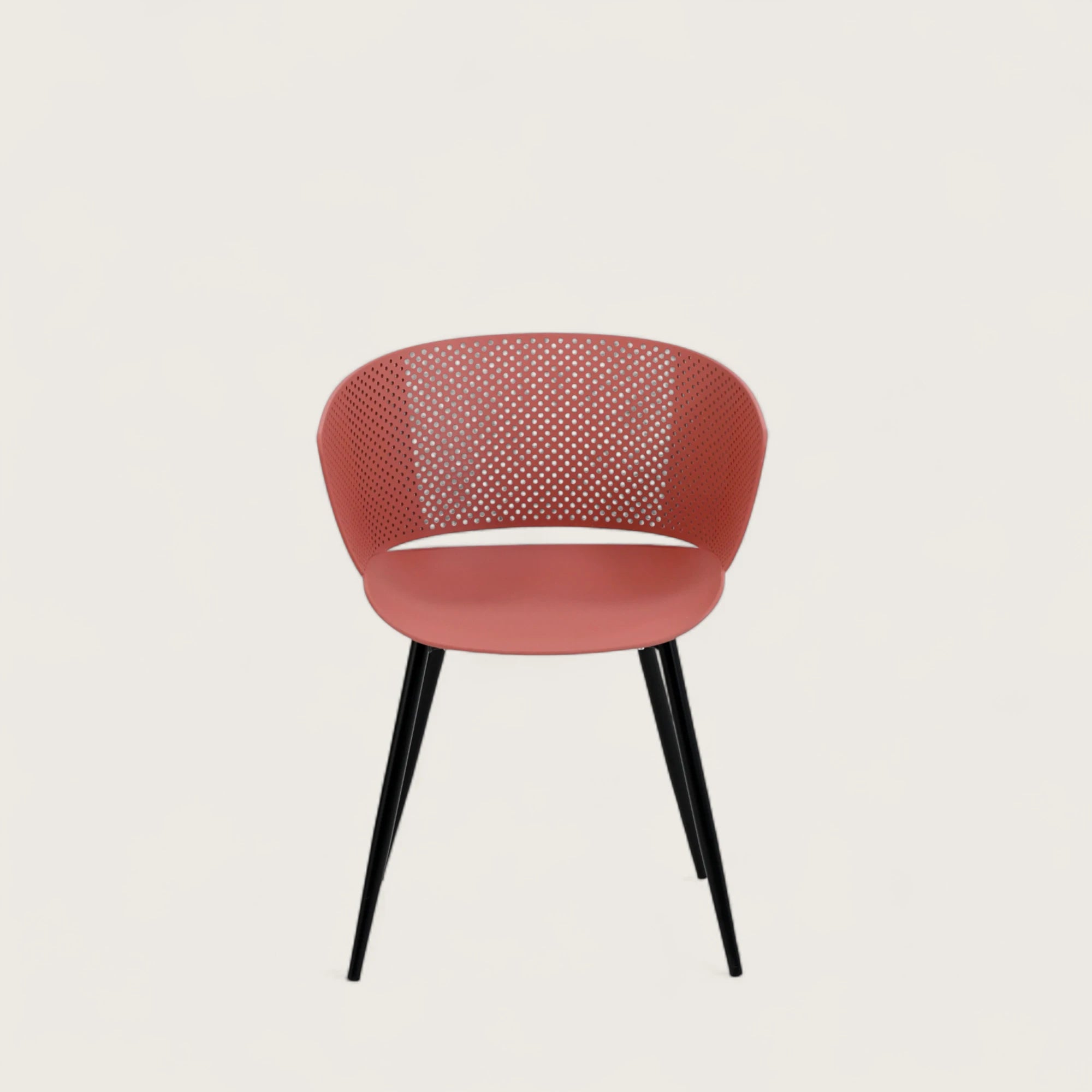 Sedia con scocca in polipropilene colore terracotta, schienale avvolgente e gambe in metallo nero opaco, ideale per ambienti interni.