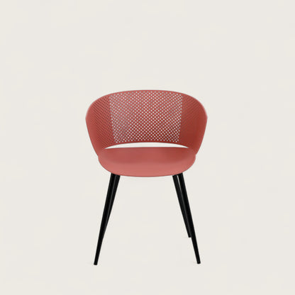 Sedia con scocca in polipropilene colore terracotta, schienale avvolgente  e gambe in metallo nero opaco, ideale per ambienti interni.